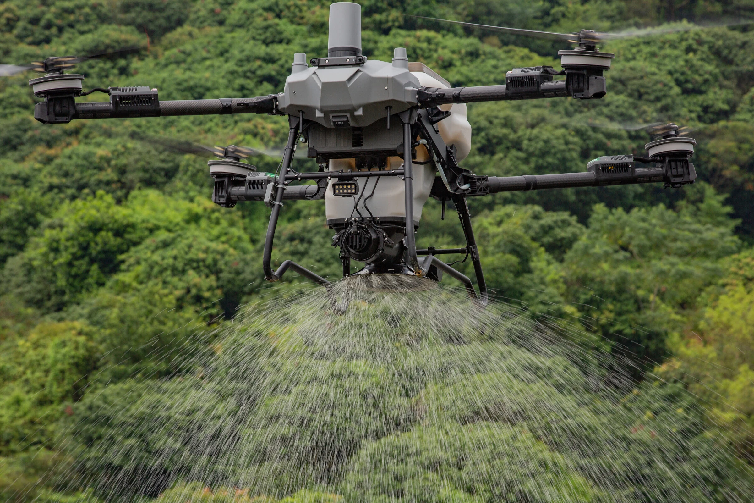 Dron DJI Agras esparciendo producto sólido en pleno vuelo